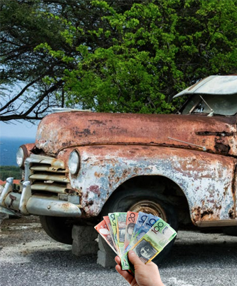 Rusted old car with a hand holding Australian cash notes, representing Cash for Cars in Glebe