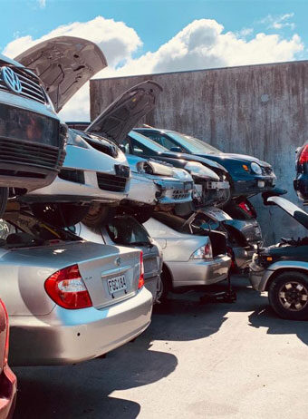 Stacked scrap vehicles in a salvage yard awaiting recycling after car removal.